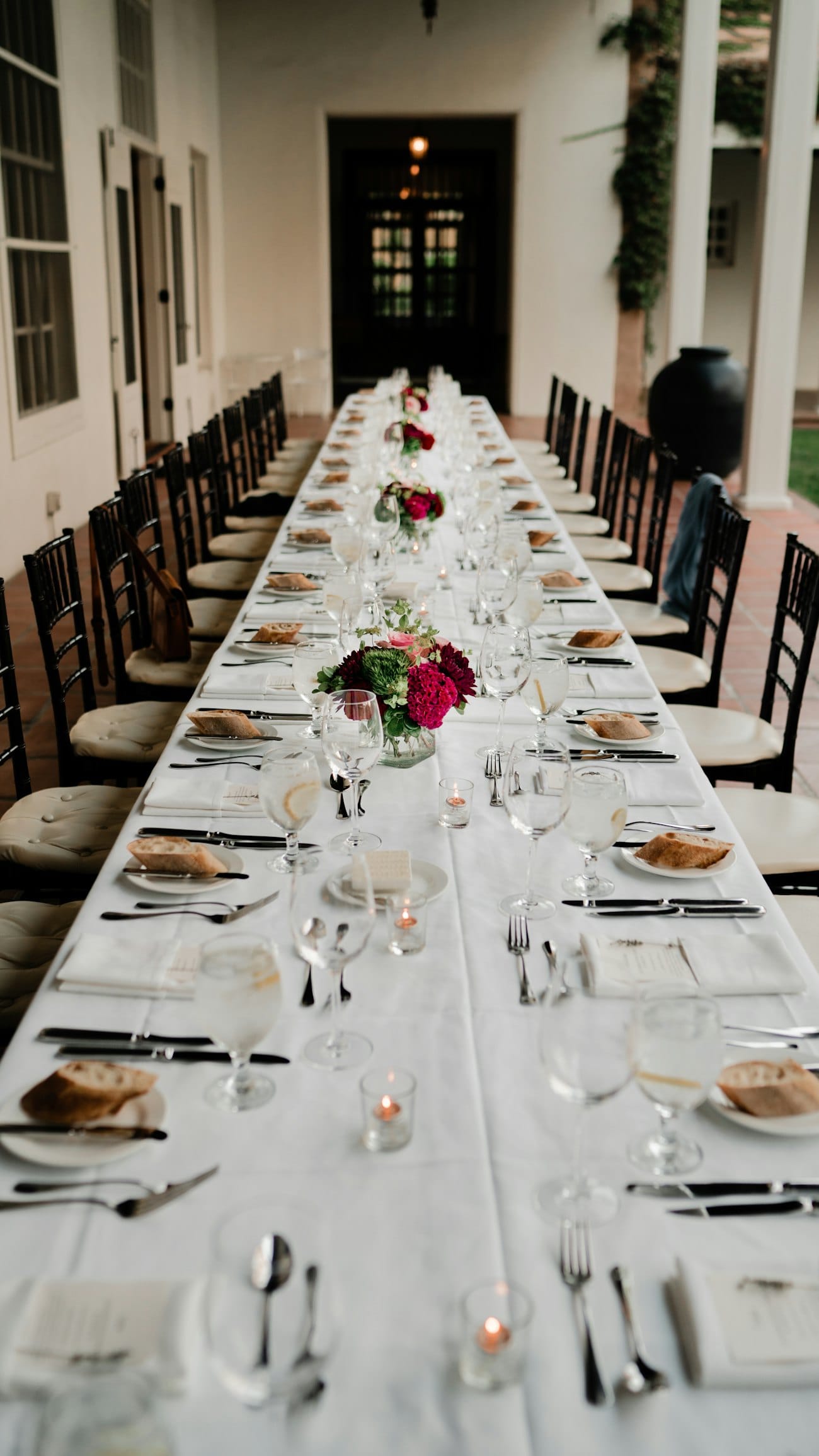 Longue table de mariage dressée avec vaisselle et verres