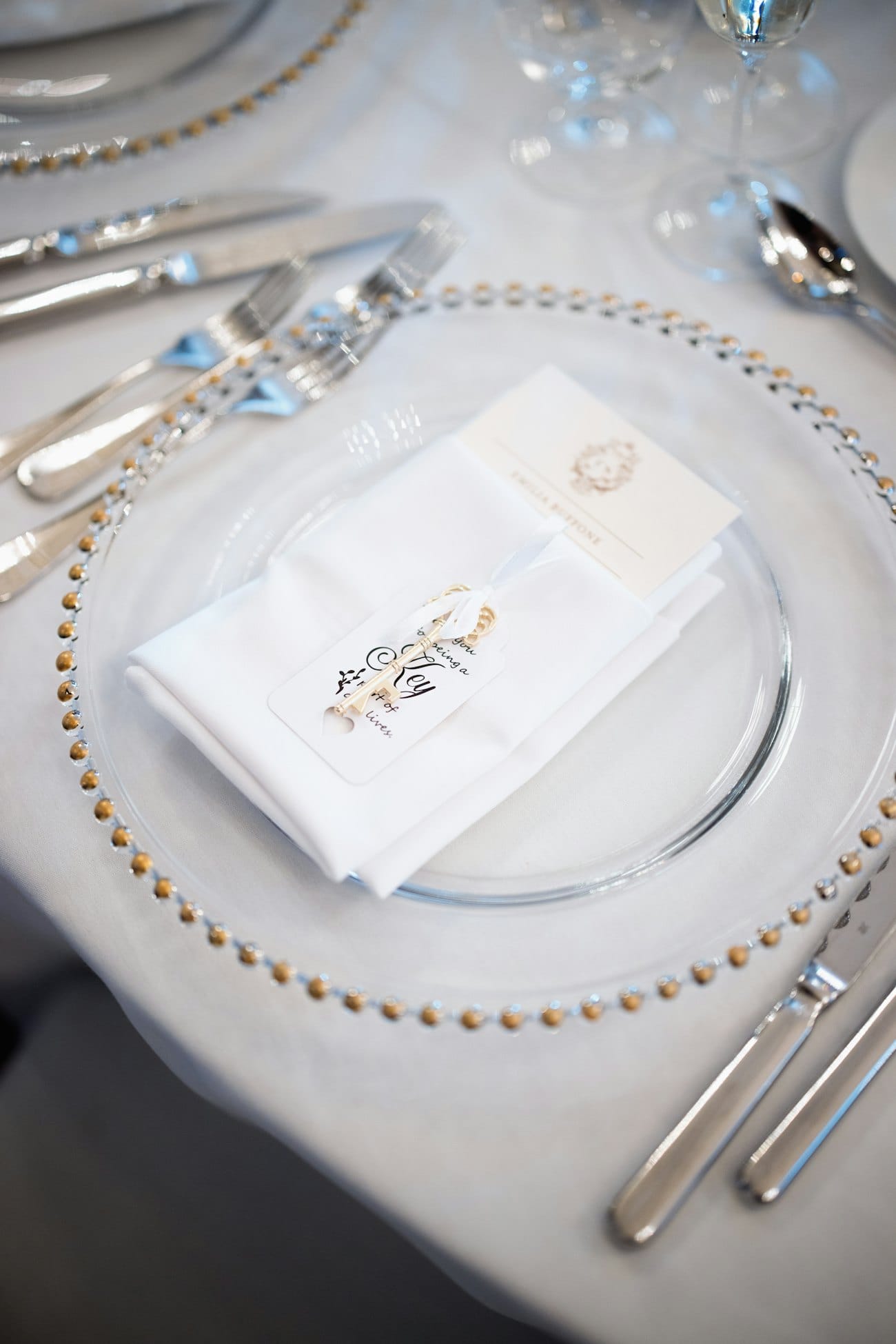 Assiette de mariage dressée avec serviette, couverts et verres